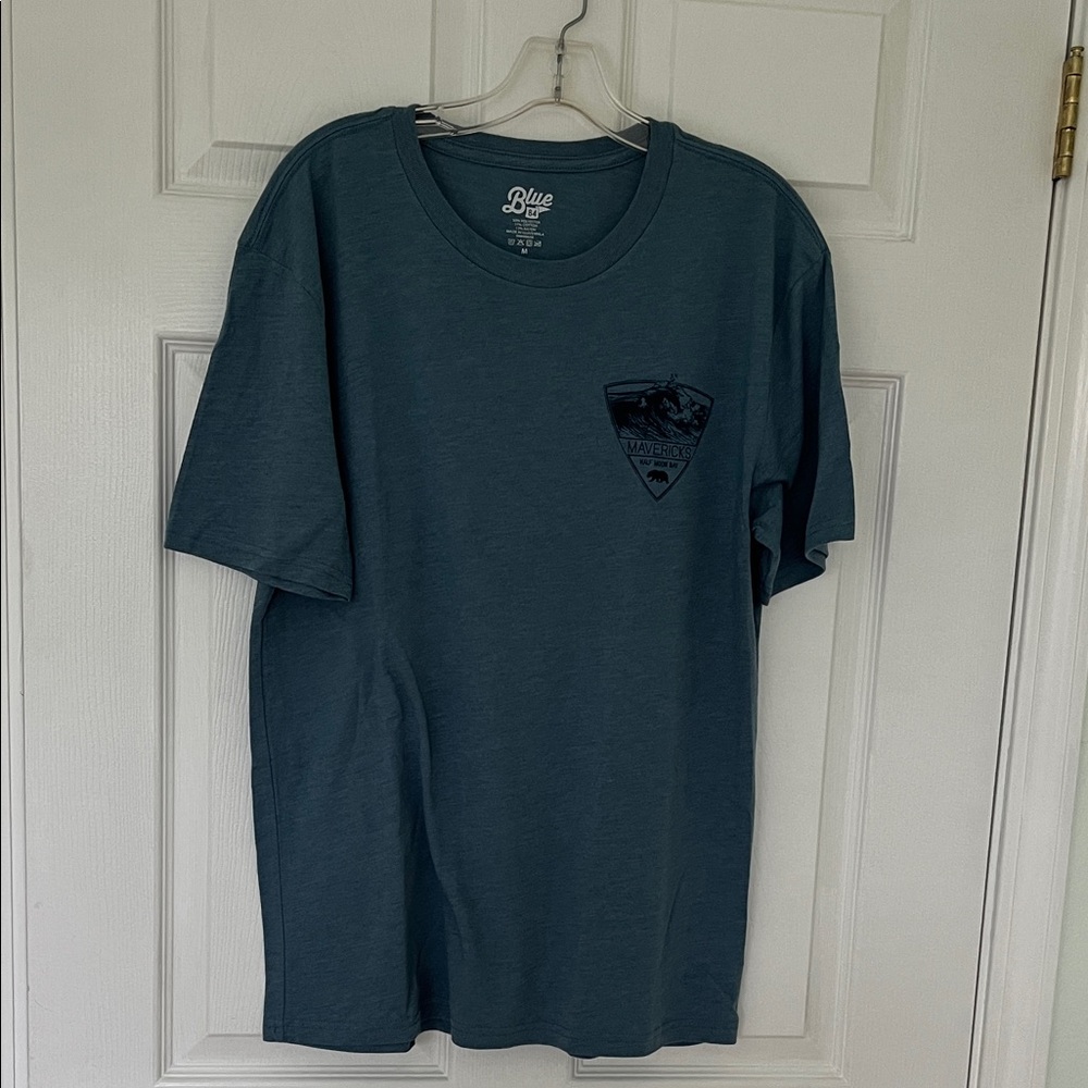 Blue short sleeved surf vibe tee featuring the Mavericks Wave in Half Moon Bay.